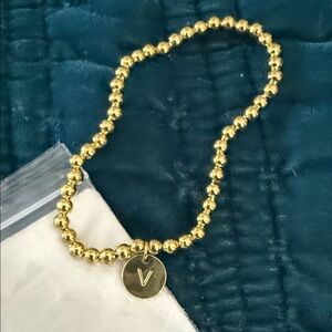 Gold Beaded Bracelet with “V” Charm NWOT and never worn.